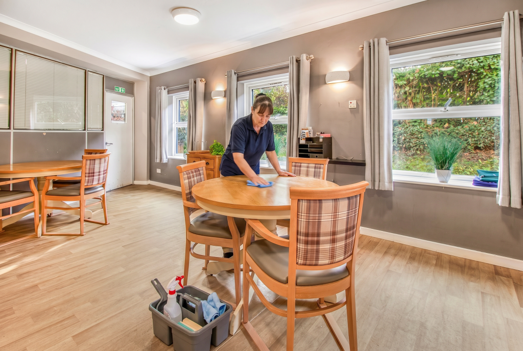 Lady cleaning a dining room table